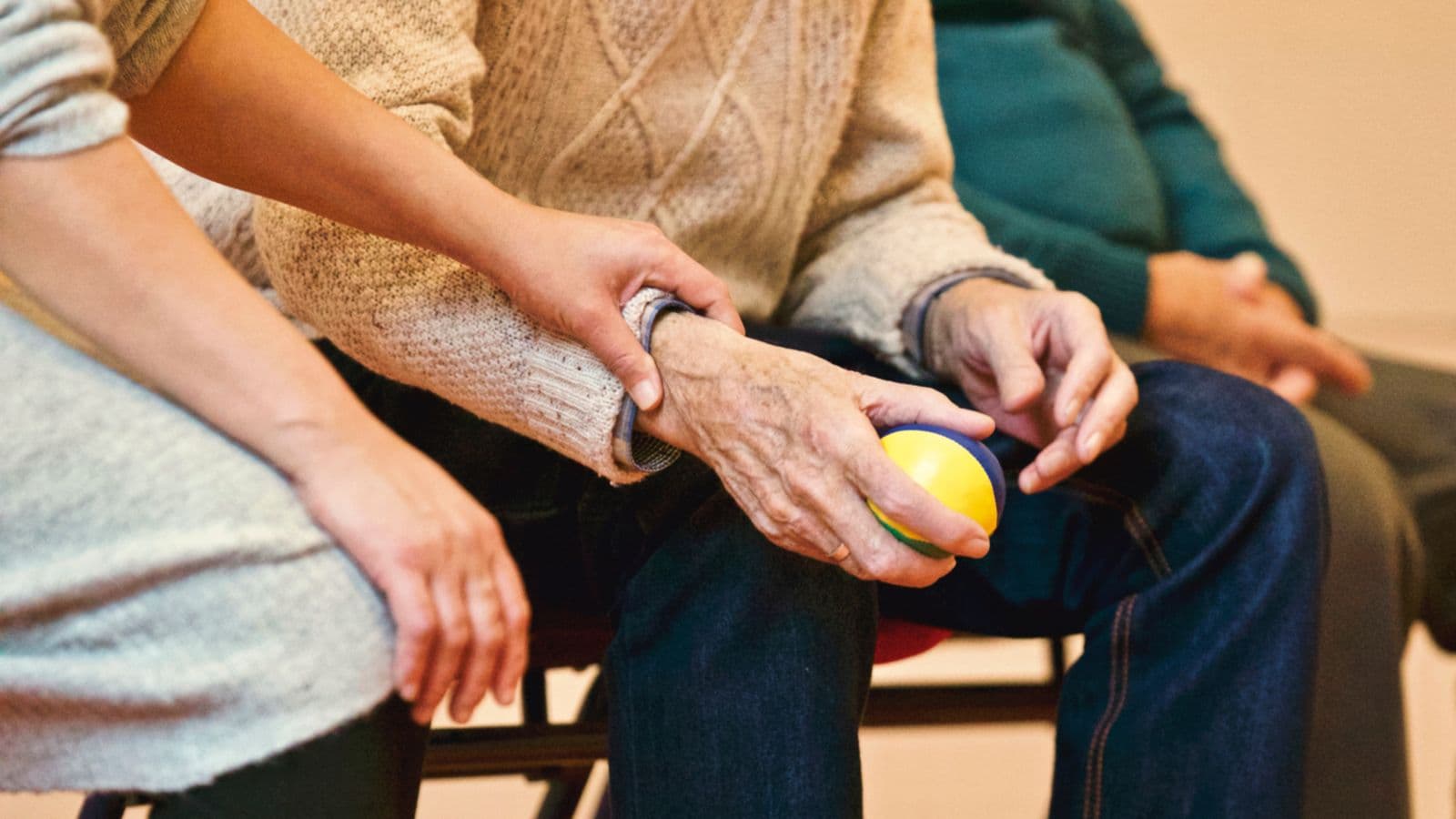 A caregiver holds hands with a resident
