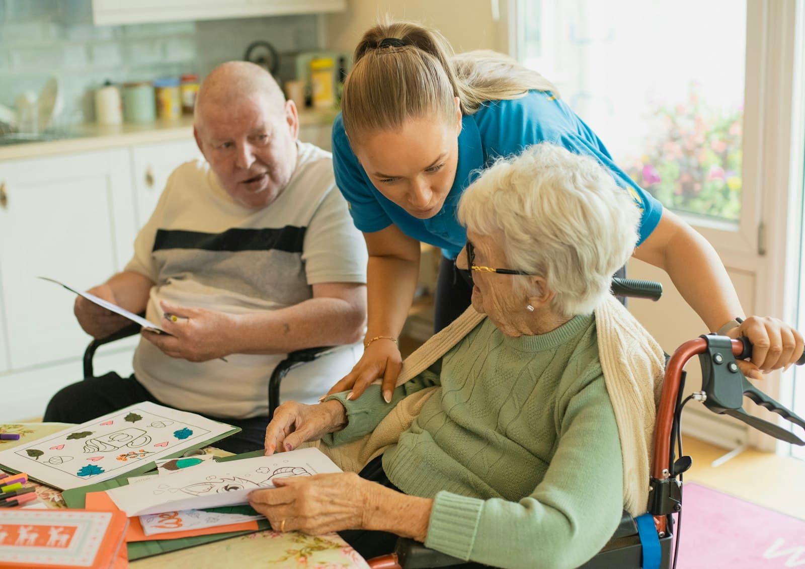 A caregiver helps residents with a hands-on activity